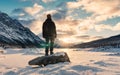 Solo young adventurer standing on snow covered lake with sunrise over Medicine Lake in morning on winter at Jasper national park