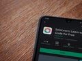 SoloLearn - Learning coding app play store page on the display of a black mobile smartphone on wooden background