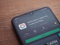 SoloLearn - Learning coding app play store page on the display of a black mobile smartphone on wooden background