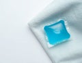 Soluble laundry detergent capsule on a neutral linen cloth with empty space for text Royalty Free Stock Photo