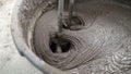 The solution in the bucket is mixed using a construction mixer. Mixing plaster solution in a bucket using electric drill. Royalty Free Stock Photo