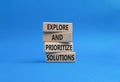 Solution symbol. Wooden blocks with words Explore and prioritize solutions. Beautiful blue background. Business and solution Royalty Free Stock Photo