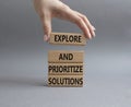 Solution symbol. Wooden blocks with words Explore and prioritize solutions. Beautiful grey background. Businessman hand. Business Royalty Free Stock Photo