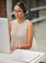 A solution to your problem is just a call away. a businesswoman using a computer while working in a call center.