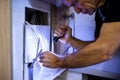 Solutions. Close up shot of aged electrician, repairman in uniform working, fixing an ethernet cable or router in fuse