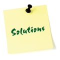 Solutions, written on a sticky adhesive note, isolated yellow post-it style sticker, black thumbtack pushpin, green text Royalty Free Stock Photo