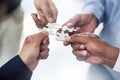 They solve problems piece by piece. High angle shot of a group of unidentifiable businesspeople holding puzzle pieces Royalty Free Stock Photo