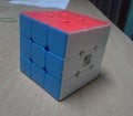 A solved Rubics cube in a table Royalty Free Stock Photo