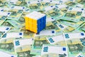 Solved rubik cube in Ukrainian flag colors over many euro banknotes, 100 euro money bills, financial decision making