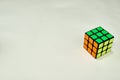 Solved rubik`s cube in yellow green and orange on white background with copy space 2