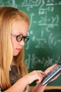 Solving complex math problems. A cute blonde girl using her calculator in class. Royalty Free Stock Photo