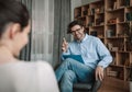 Solving of problem and meeting with psychologist. Smiling european millennial man doctor gesturing Royalty Free Stock Photo