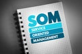 SOM - Service Oriented Management acronym on notepad, business concept background