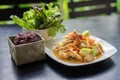 Som Tum Fruit Salad or Sour Spicy Thai fruit salad with Black Glutinous Rice in basket, Popular Thai-Eastern fusion food