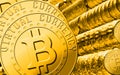 Some bitcoins laying on blurred golden rings background with a single bitcoin in sharp focus