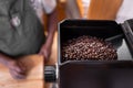 Some black coffee beans are inside of the grind machine hopper Royalty Free Stock Photo