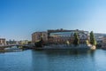 Boats pass by riverside buildings