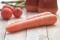 Some carrots on a white wooden table in a rustic kitchen.