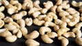Some cashew seeds on background. Cashew nuts are scattered as a background on a black base. Peeled cashews closeup.