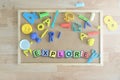 Some colored cube letters on a blackboard in a classroom forming the word EXPLORE.