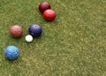 Some colored lawn bowls clustered around the jack