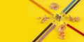 Some colored pencils of different colors and a pencil sharpener and pencil shavings on ÃÂ° yellow background Royalty Free Stock Photo