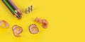 Some colored pencils of different colors and a pencil sharpener and pencil shavings on ÃÂ° yellow background Royalty Free Stock Photo