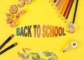 Some colored pencils of different colors and a pencil sharpener and pencil shavings on the yellow background. Word back to school Royalty Free Stock Photo