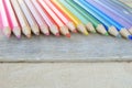 Some colored pencils on a white wooden table.