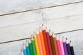 Some colored pencils on a white wooden table.