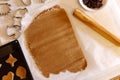 Some cookies cutter shapes on raw cookie dough, one with heart shape, another one - squirrel. Wooden roller on the table. Holiday