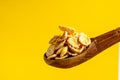 some cornflakes on a wooden spoon on a yellow background Royalty Free Stock Photo