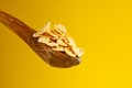 some cornflakes on a wooden spoon on a yellow background Royalty Free Stock Photo