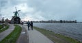 Couples walk near windmill at Zaanse Schans, Netherlands