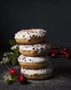 Some delicious donuts at each other with cherry berry on dark background colorful sprinkles front Royalty Free Stock Photo