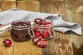 Some delicious ripe cherries and berry jam in glass containers Royalty Free Stock Photo