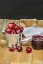 Some delicious ripe cherries inside a metal bucket and red fruit jam Royalty Free Stock Photo