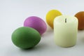 Some easter eggs, with a white easter-candle, isolated on white background, colored by easter bunny