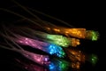 Some fibre optic cables glowing at the end in different colors against a black background created with generative AI technology