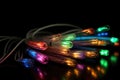 Some fibre optic cables glowing at the end in different colors against a black background created with generative AI technology