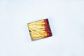 Some flammable red fire matches gathered in a small match box before a white background