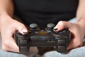 A young girl plays video games with a black joystick with many b Royalty Free Stock Photo