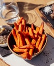 French fries served in a bowl on a wooden table. Sweet potatoes Royalty Free Stock Photo