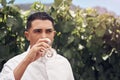 Some fresh air and wine is all you need. a handsome young man having a glass of wine on a vineyard. Royalty Free Stock Photo