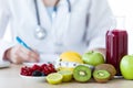 Some fruits such as apples, kiwis, lemons and berries on nutritionist table. Royalty Free Stock Photo