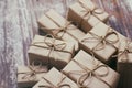 Some gift boxes wrapped in brown craft paper and tie hemp cord. Decorative wooden background. Your text space. Set of presents. Royalty Free Stock Photo