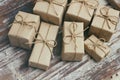 Some gift boxes wrapped in brown craft paper and tie hemp cord. Decorative wooden background. Your text space. Set of presents. Royalty Free Stock Photo