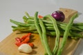 Some green beans, some red chili peppers, two cloves of garlic and a red onion Royalty Free Stock Photo