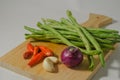 Some green beans, some red chili peppers, two cloves of garlic and a red onion Royalty Free Stock Photo