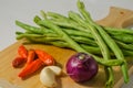 Some green beans, some red chili peppers, two cloves of garlic and a red onion Royalty Free Stock Photo